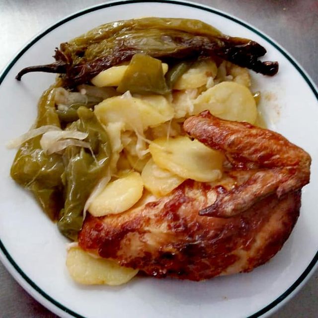 plato con medio pollo asado patatas y pimientos